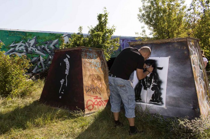 Otto Schade stenciling "Cop for a load" in Berlin | Art-Pie